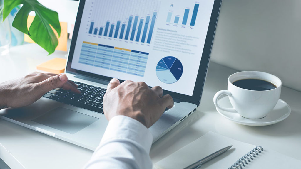 Young businessman typing computer laptop with graph chart